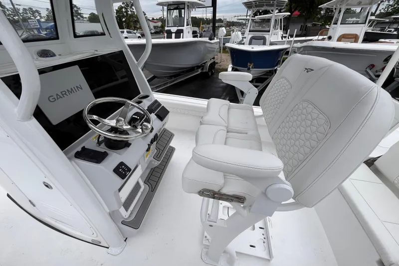 Slide: The Image of 2026 Tidewater 2500 Carolina Bay boat interior with Garmin navigation and white seating. - 14