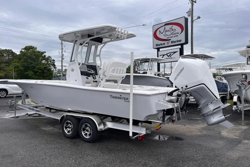 Slide: The Image of 2026 Tidewater 2500 Carolina Bay boat on trailer at dealership, featuring Mercury outboard engine. - 2
