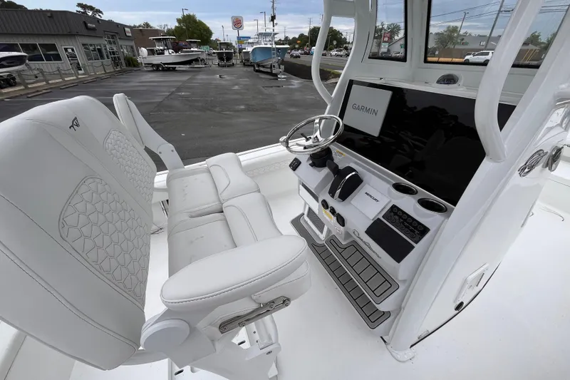 Slide: The Image of 2026 Tidewater 2500 Carolina Bay boat interior with Garmin navigation system and white seating. - 7