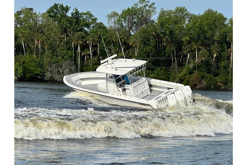 The Image of 2024 Contender 39 ST boat cruising on water with trees in background. - 0
