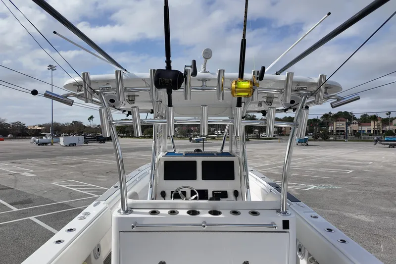 Slide: The Image of 2024 Contender 39 ST boat with fishing rods and console in a parking lot. - 22