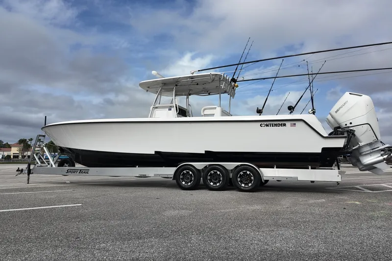 Slide: The Image of 2024 Contender 39 ST boat on trailer, equipped with fishing rods and Mercury engines. - 5