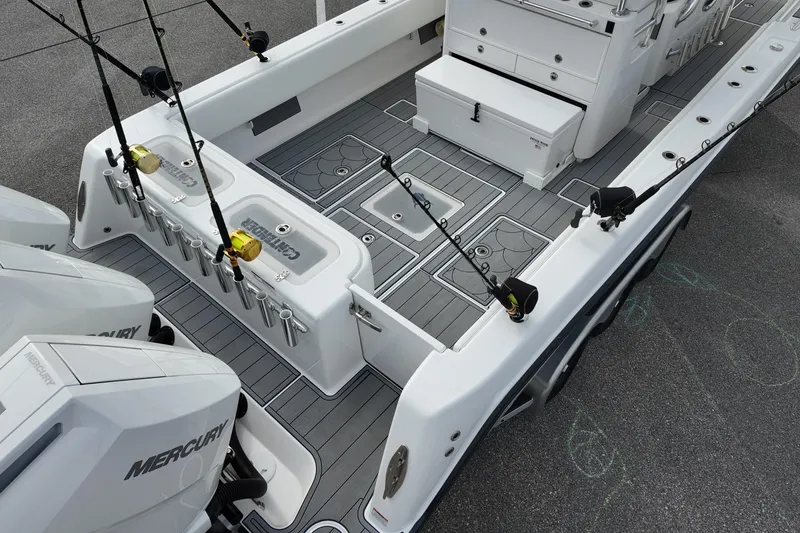 Slide: The Image of 2024 Contender 39 ST fishing boat deck with rod holders and Mercury engines. - 6