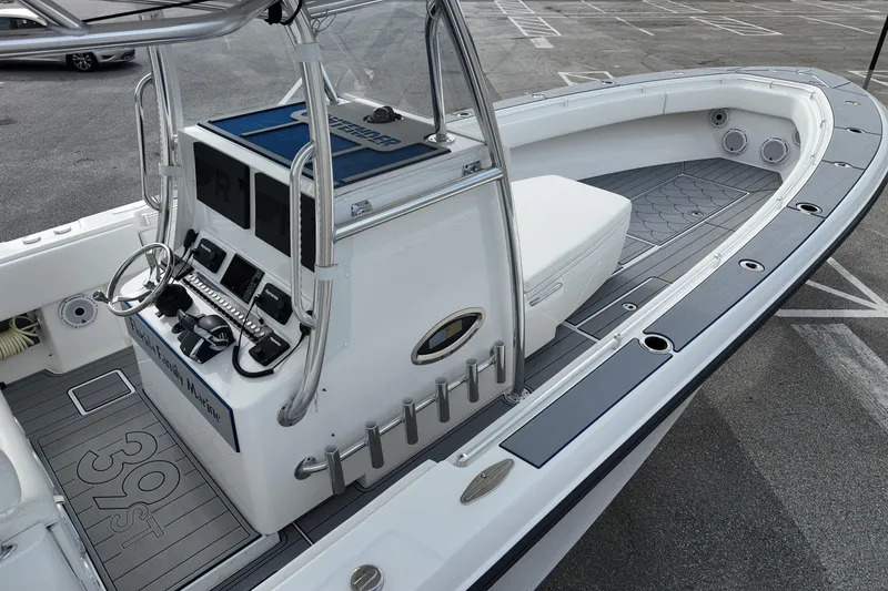 Slide: The Image of 2024 Contender 39 ST boat interior with modern console and seating in a parking lot. - 7