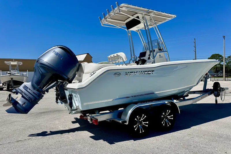 Slide: The Image of 2026 Key West 203 FS boat with Yamaha outboard engine on a trailer, parked outdoors. - 12