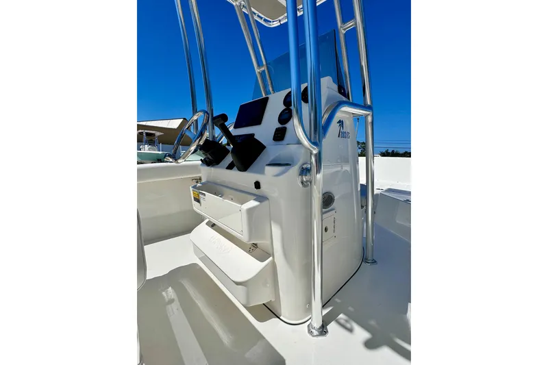 Slide: The Image of 2026 Key West 203 FS boat console with steering wheel and controls, under clear blue sky. - 17
