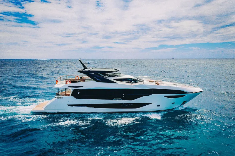 The Image of 2024 Sunseeker 100 Yacht cruising on open ocean under a partly cloudy sky. - 1