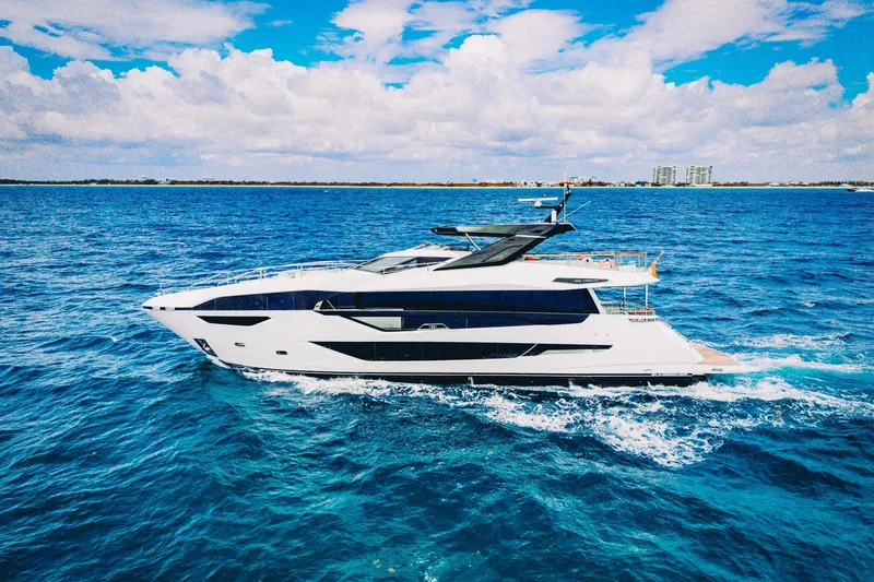 Slide: The Image of 2024 Sunseeker 100 Yacht cruising on vibrant blue ocean under a partly cloudy sky. - 44