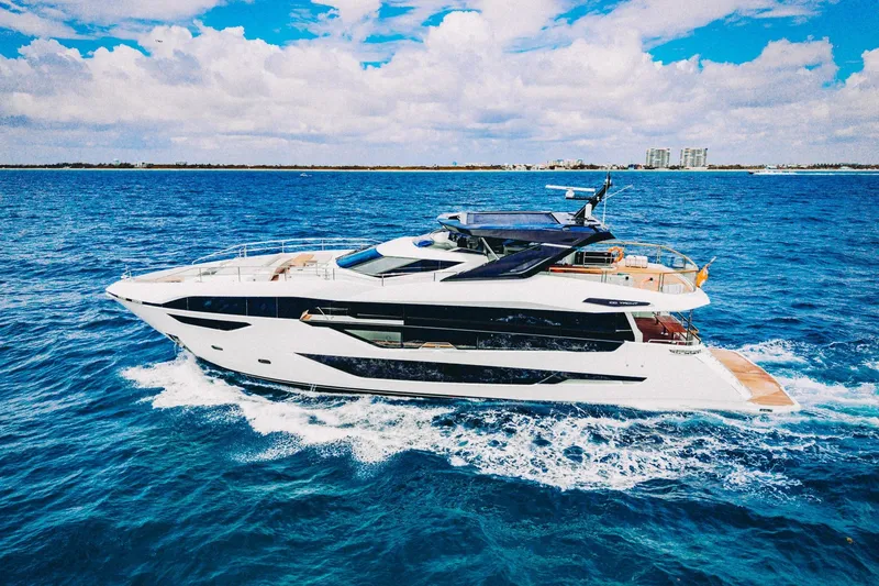 Slide: The Image of 2024 Sunseeker 100 Yacht cruising on open blue ocean under a partly cloudy sky. - 5