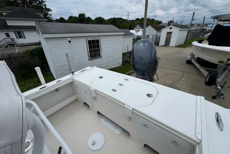 Slide: The Image of 2014 Steiger Craft 21 Tournament boat with outboard motor, parked near white buildings. - 6