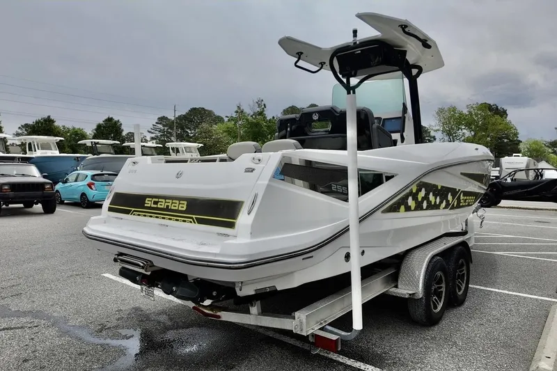 Slide: The Image of 2020 Scarab 255 ID boat on trailer in parking lot, overcast sky. - 4