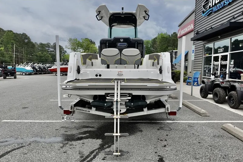 Slide: The Image of 2020 Scarab 255 ID boat displayed at dealership with trailer and outdoor seating. - 5