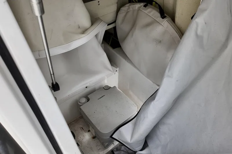 Slide: The Image of Interior of a 2020 Scarab 255 ID boat with storage compartment and portable toilet. - 7