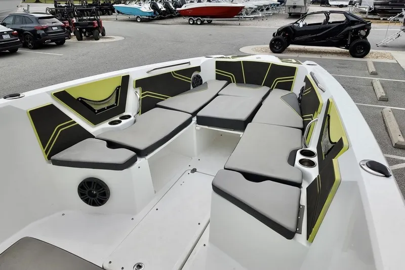 Slide: The Image of 2020 Scarab 255 ID boat interior with gray and green seating in a parking lot. - 8