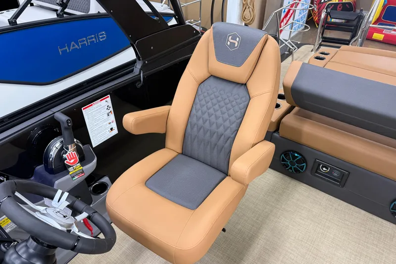 Slide: The Image of Captain's chair in 2026 Harris Sunliner 230 boat, featuring tan and gray upholstery. - 9