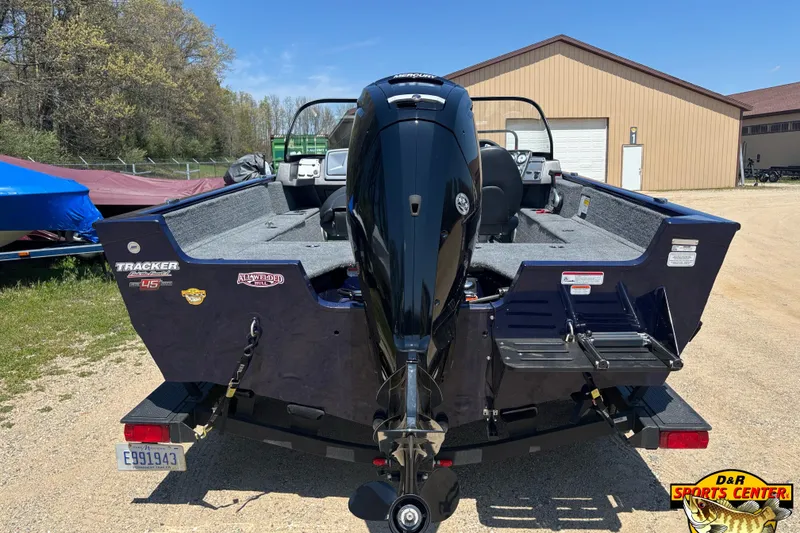 Slide: The Image of 2023 Tracker Pro Guide V-175 WT boat with outboard motor, parked outdoors. - 4