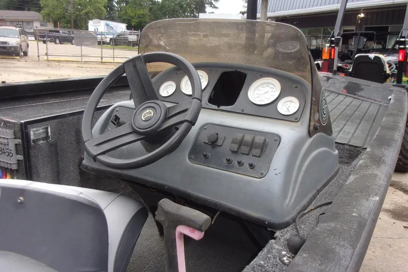 Slide: The Image of 2006 Triton TS-17 boat dashboard with steering wheel and gauges in outdoor setting. - 10