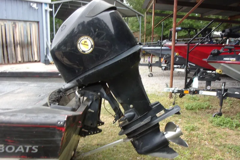 Slide: The Image of 2006 Triton TS-17 outboard motor on a boat trailer in a yard setting. - 13