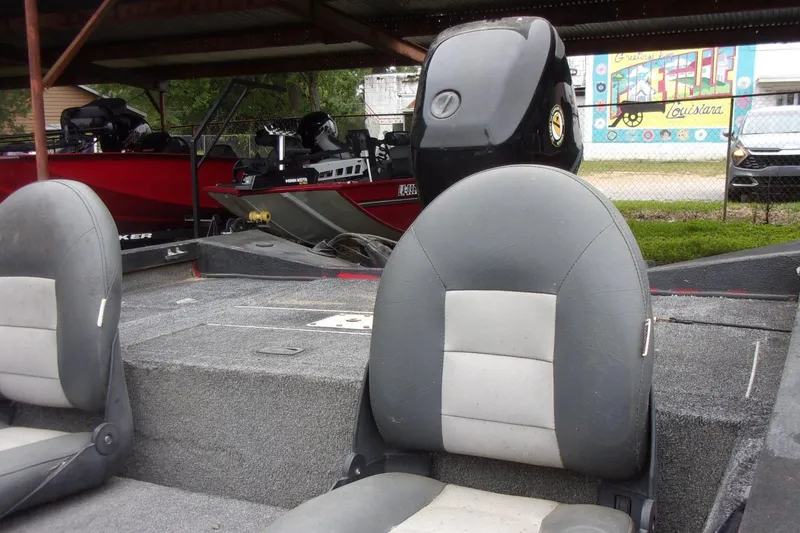 Slide: The Image of 2006 Triton TS-17 boat interior with gray seats, parked under a shelter. - 6