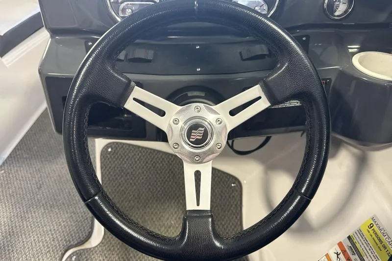 Slide: The Image of Steering wheel of 2016 Four Winns 190 Freedom boat, featuring sleek black and silver design. - 14