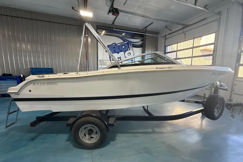 Slide: The Image of 2016 Four Winns 190 Freedom boat on trailer in indoor garage setting. - 6
