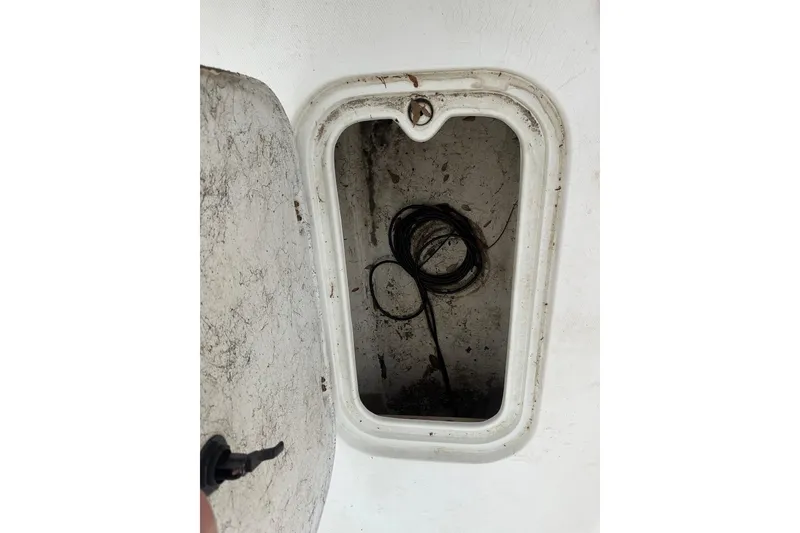 Slide: The Image of Open storage compartment on a 2002 Polar 2300 Bay boat, showing coiled wires inside. - 11
