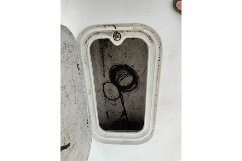 Slide: The Image of Open storage compartment on a 2002 Polar 2300 Bay boat, showing coiled rope inside. - 12