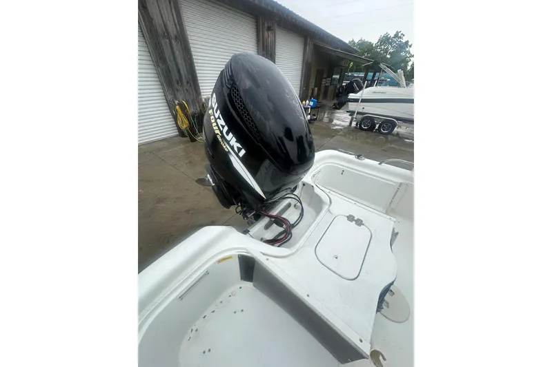 Slide: The Image of 2002 Polar 2300 Bay boat with Suzuki outboard motor in a marina setting. - 19