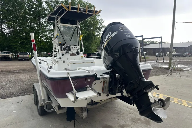 Slide: The Image of 2002 Polar 2300 Bay boat with Suzuki outboard motor on trailer, parked outdoors. - 3