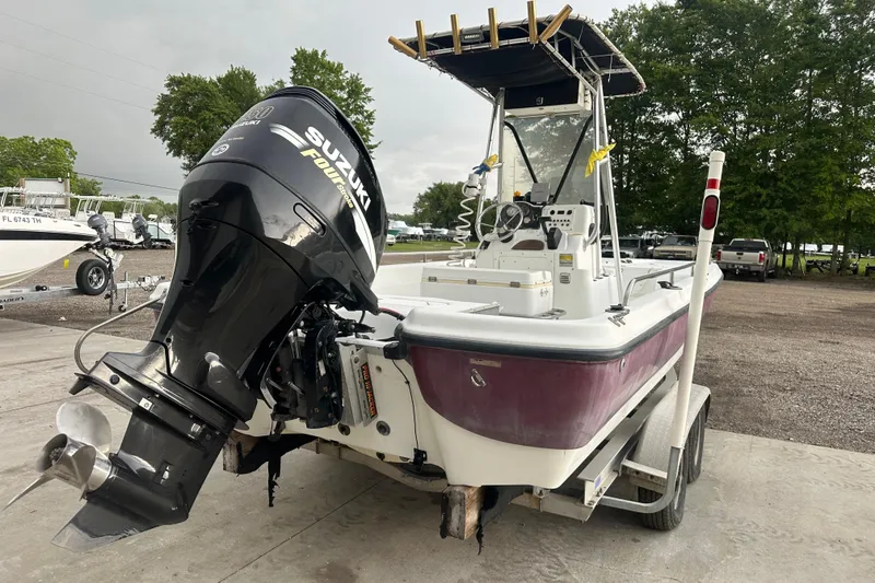 Slide: The Image of 2002 Polar 2300 Bay boat with Suzuki outboard motor on trailer, parked outdoors. - 4