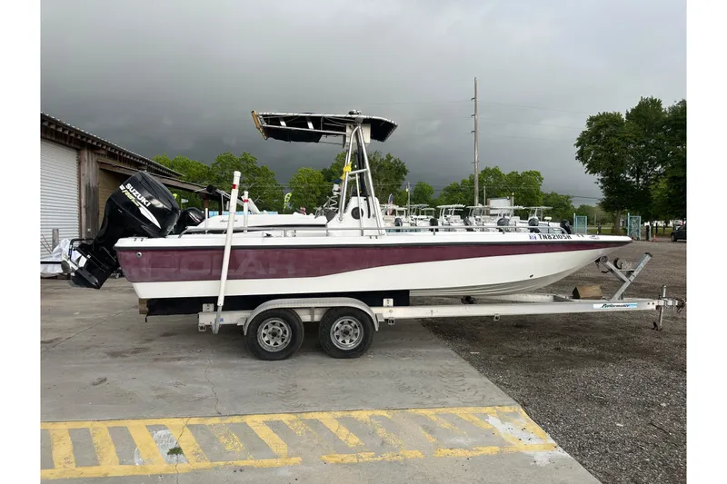 Slide: The Image of 2002 Polar 2300 Bay boat on trailer with Suzuki outboard motor, parked outdoors. - 6