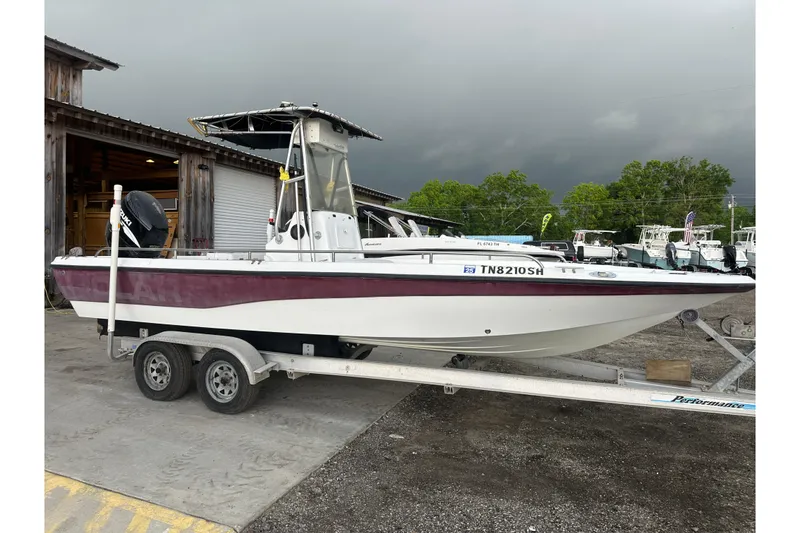 Slide: The Image of 2002 Polar 2300 Bay boat on trailer, parked outdoors under cloudy sky. - 7