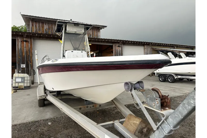 Slide: The Image of 2002 Polar 2300 Bay boat on trailer, parked outside a wooden building. - 8