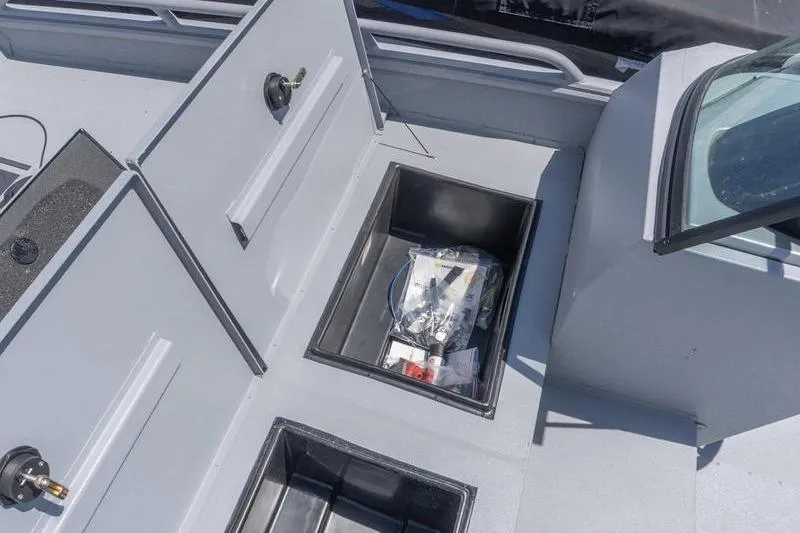 Slide: The Image of 2026 G3 Sportsman 2400 boat storage compartments with open lids and visible contents. - 12