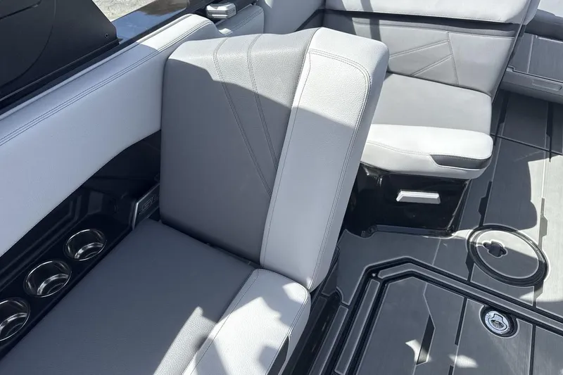 Slide: The Image of 2024 Supra SL 550 boat interior with gray seating and cup holders. - 26