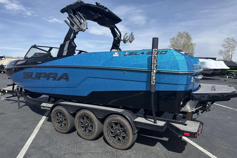 Slide: The Image of 2024 Supra SL 550 boat in vibrant blue on a trailer, showcasing sleek design and modern features. - 3