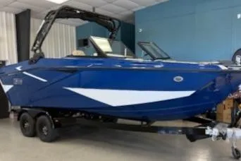 The Image of 2026 Heyday H22 boat in showroom, featuring sleek blue and white design on trailer. - 0