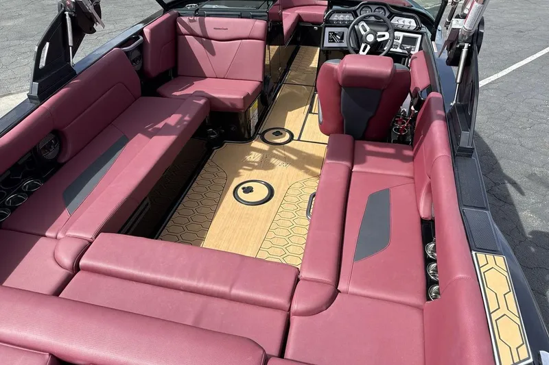 Slide: The Image of 2023 MasterCraft NXT22 boat interior with maroon seating and stylish dashboard. - 10