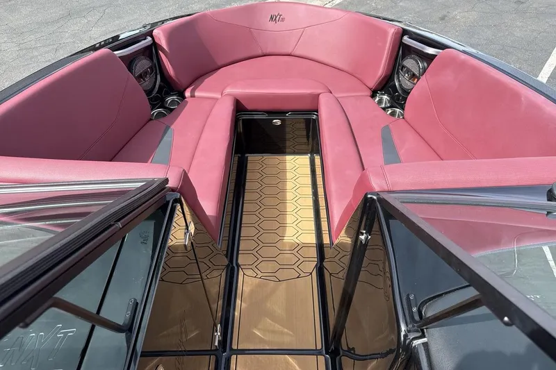 Slide: The Image of 2023 MasterCraft NXT22 boat interior with pink seating and hexagonal floor design. - 11