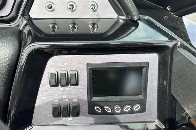 Slide: The Image of Control panel of 2023 MasterCraft NXT22 boat with switches and display screen. - 15