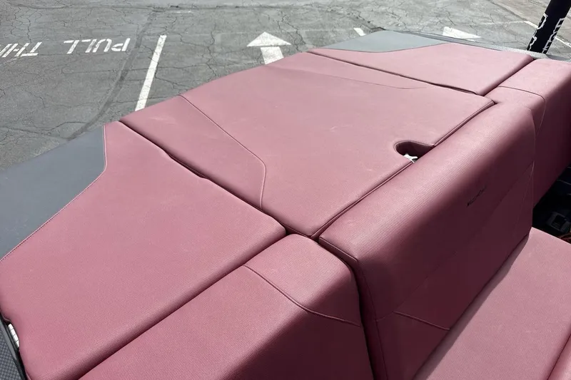 Slide: The Image of 2023 MasterCraft NXT22 boat with maroon upholstery in a parking lot. - 19