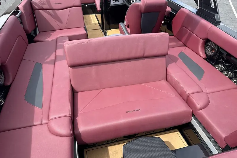 Slide: The Image of 2023 MasterCraft NXT22 boat interior with luxurious red seating and modern design. - 23