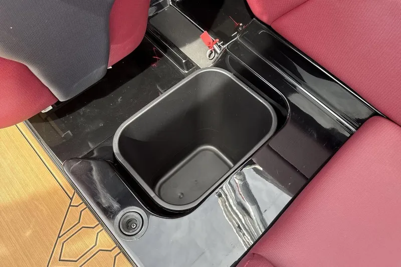 Slide: The Image of 2023 MasterCraft NXT22 boat interior with red seats and black storage compartment. - 24