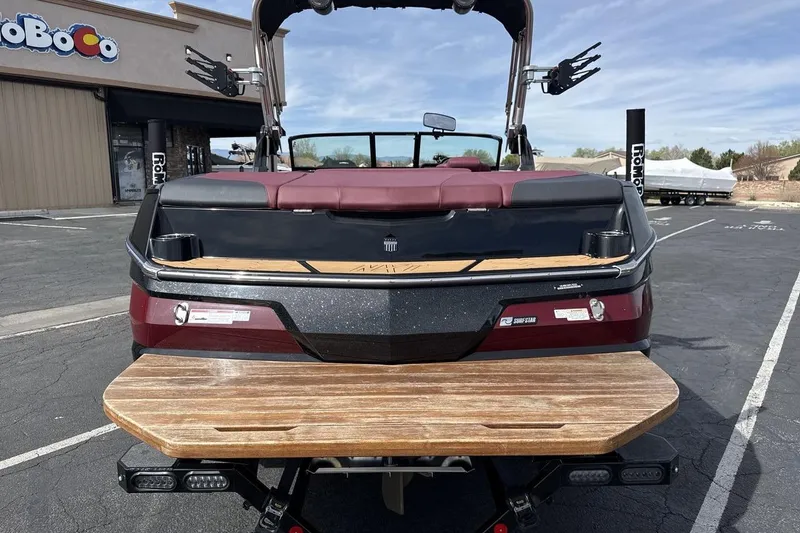 Slide: The Image of 2023 MasterCraft NXT22 boat rear view with swim platform in parking lot. - 4