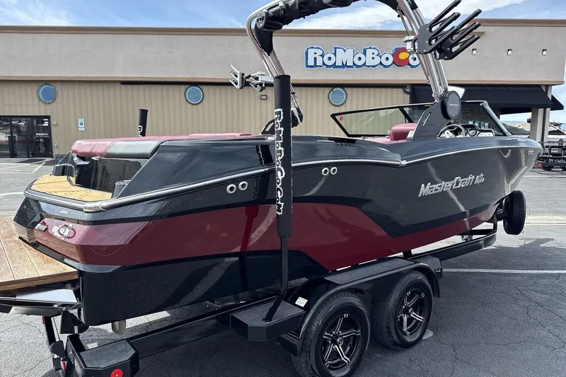 Slide: The Image of 2023 MasterCraft NXT22 boat on trailer, parked outside a building. - 5