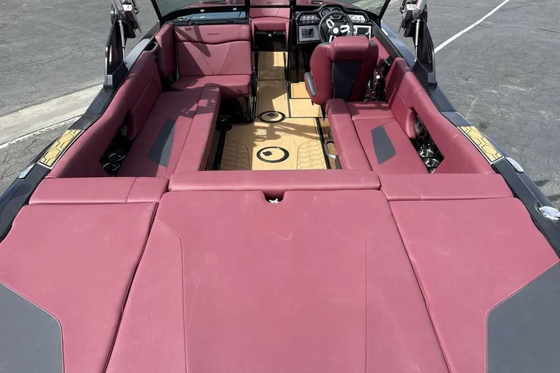 Slide: The Image of 2023 MasterCraft NXT22 boat interior with maroon seating and modern dashboard design. - 9