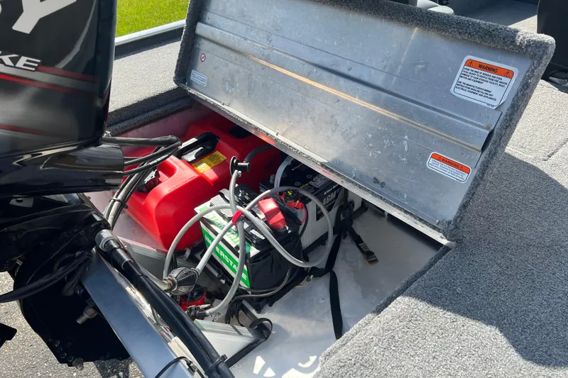 Slide: The Image of Open storage compartment in 2019 Tracker Bass Tracker Classic XL boat, showing battery and fuel tank. - 15