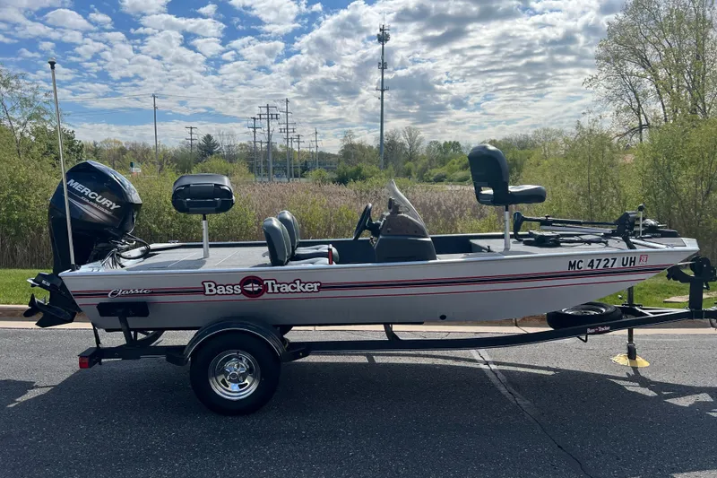 The Image of 2019 Tracker Bass Tracker Classic XL boat on trailer, parked outdoors under cloudy sky. - 2