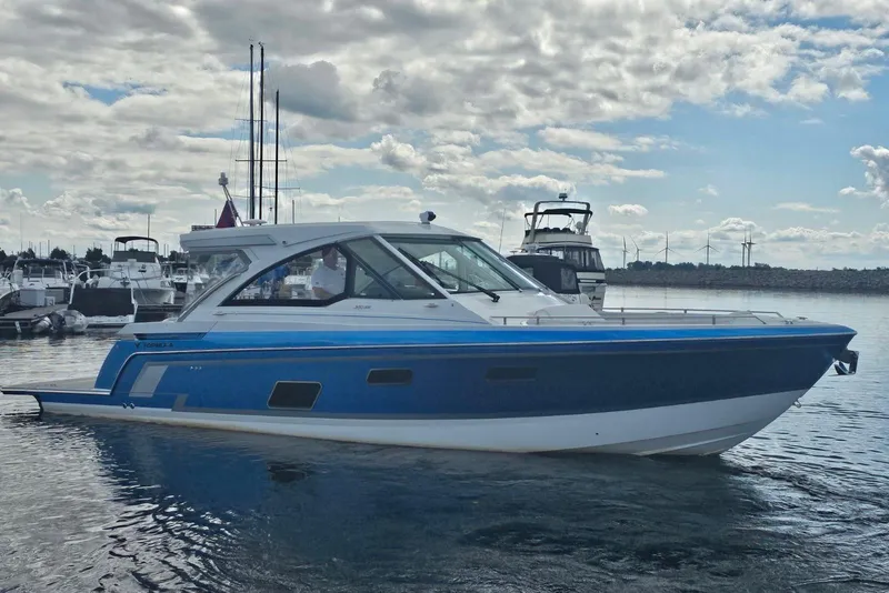 The Image of 2022 Formula 380 Super Sport Crossover I/O boat on calm water under cloudy sky. - 0