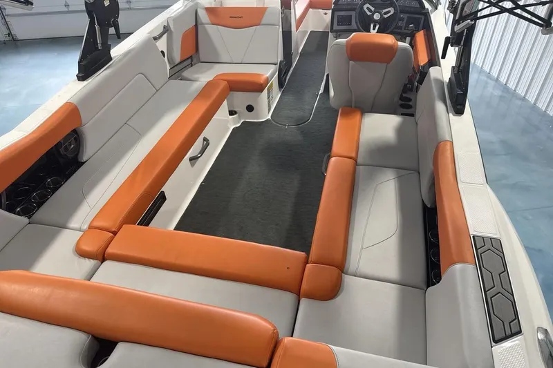 Slide: The Image of 2021 MasterCraft NXT24 boat interior with orange and gray seating, spacious layout. - 10